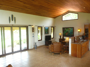 The open plan LR/kitchen building has a cathedral ceiling and a long array of sliding glass doors opening to the veranda and pool.