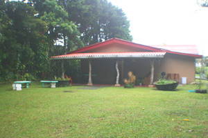 The large back patio looks over a large yard through woods to a partial lake view.