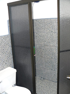 The bathroom has new fixtures, including a large shower stall.