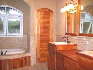 The master bathroom is a commodious space with fine woodwork and a jacuzzi tub as well as a shower.