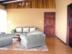 The living room is a large and bright part of the open interior with cathedral ceilings and sliding glass doors onto the beautiful veranda.