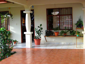 The spacious flower-filled porch is preceeded by a covered carport with tile floor.