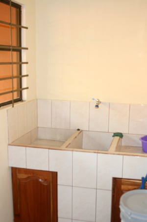 The laundry room includes a typical three-part tiled built-in sink or "pila."