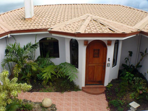 A courtyard joins the two buildings. Here the entrance to the main house is seen from the second-floor apartment over the two-car garage.