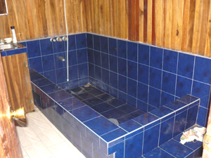 The bathroom has a very large custom-poured tile tub.