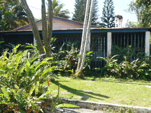 The main house has a wide veranda on all sides.