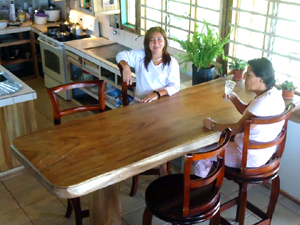 A kitchen table is a handsome large slab of hardwood, which, though large, has lots of space around it.