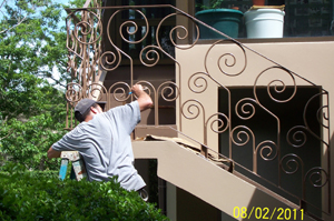 A orkman repaints some of the home's wrought ironwork according to North American standards.