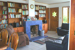 The living room, part of the wonderful open area, contains a fireplace and library shelves. The furiture may be included with the property.