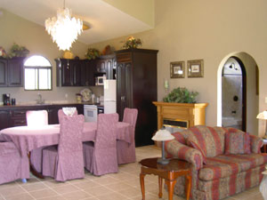 The kitchen occupies a corner of the great room. A moveable gas fireplace is placed along one wall.