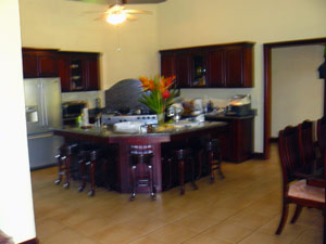 The kitchen is a very large part of the open area with much cabinetry and an L-shaped island. 