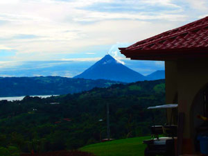 A dawn view from the parking area beside the house shows Arenal Volcano.