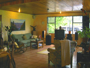 The living room and dining area form a large open plan with large windows looking out on the gardens and lake.