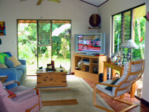 The open-concept living area looks out through large windows on lush landscaping and long views. 