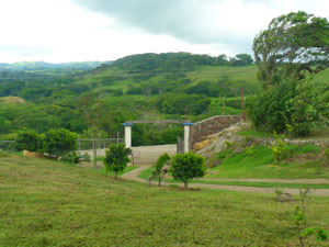 The electrically operated entrance gate is beside the newly improved road to Libano. Beyond it are a long series of beautiful semi-forested hills. 