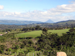 Beyond the village of San Luis, athe Arenal Volcano punctuates the horizon.