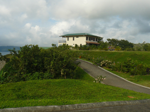 Another two-story house sits atop a hill high above the cove.